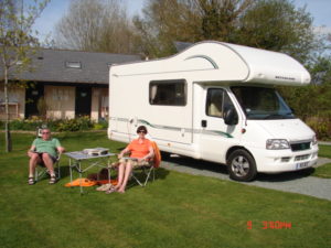 A couple relaxing outside their motor home at daisy bank 